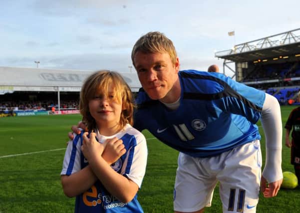 Posh manager Grant McCann with a previous Posh mascot in the days when he was first team captain.