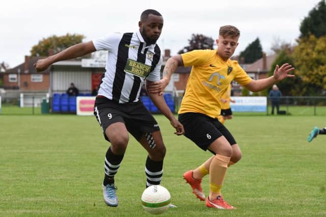 Jamar Dobson (stripes) scored for Peetrborough Northern Star at Yaxley.